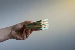 mão de uma pessoa entregando dinheiro de um empréstimo online