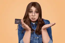 mulher com expressão triste por ter o cartão de crédito negado